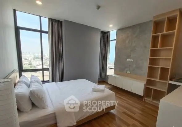 Spacious modern bedroom with large windows and city view