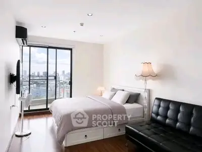 Modern bedroom with city view, featuring sleek furniture and ample natural light.