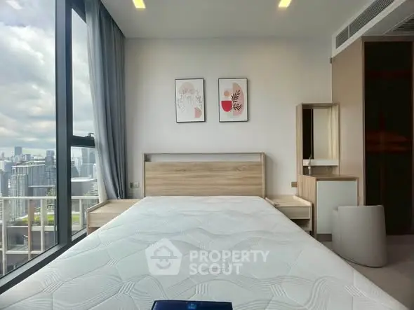 Modern bedroom with city view, featuring stylish decor and large windows for natural light.
