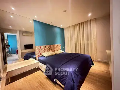 Spacious bedroom with modern decor and cozy ambiance, featuring a large bed and stylish lighting.