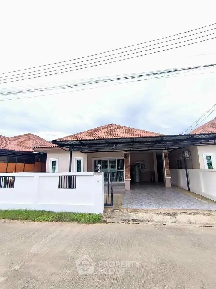 Charming single-story house with tiled roof and spacious driveway in a serene neighborhood.
