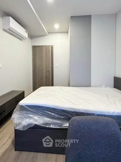 Modern bedroom with sleek furniture and air conditioning in a contemporary apartment.