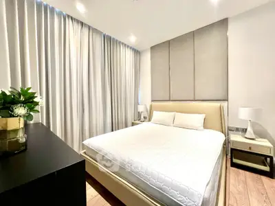 Modern bedroom with elegant decor and natural light, featuring a comfortable bed and stylish furnishings.