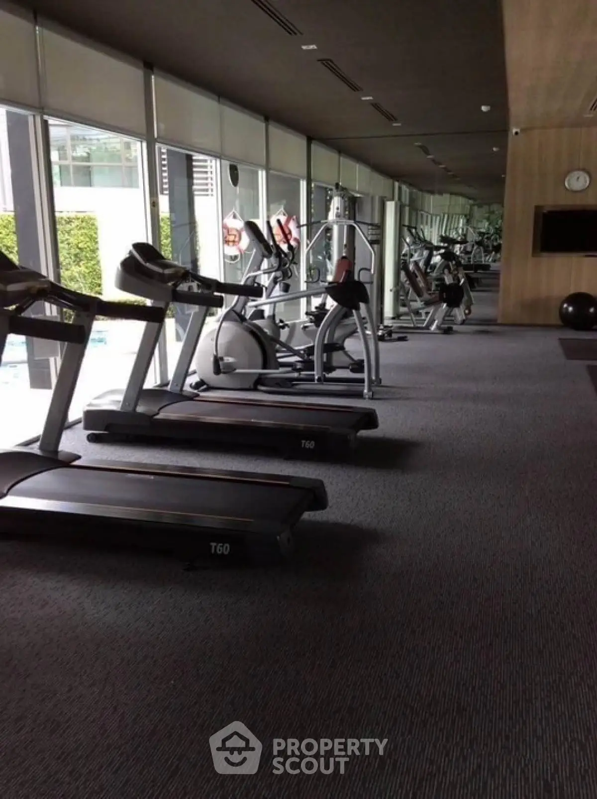 Modern gym with treadmills and exercise equipment in luxury apartment complex