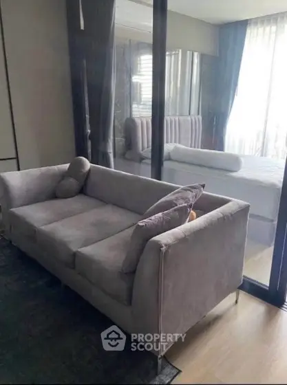 Modern living room with sleek gray sofa and large window view