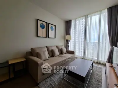 Modern living room with large windows and stylish decor in high-rise apartment.