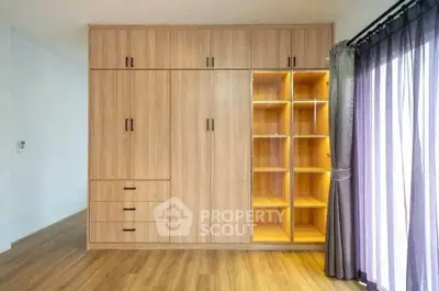 Spacious bedroom with built-in wooden wardrobe and natural light