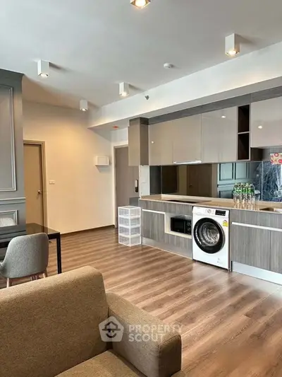Modern open-layout kitchen with sleek cabinetry and in-built washing machine