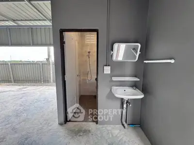 Modern industrial-style bathroom with concrete floor and sleek fixtures