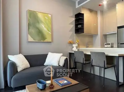Modern living room with stylish kitchen, cozy sofa, and elegant decor in a contemporary apartment.