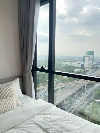 Stunning bedroom with floor-to-ceiling windows offering a breathtaking city view, perfect for urban living.