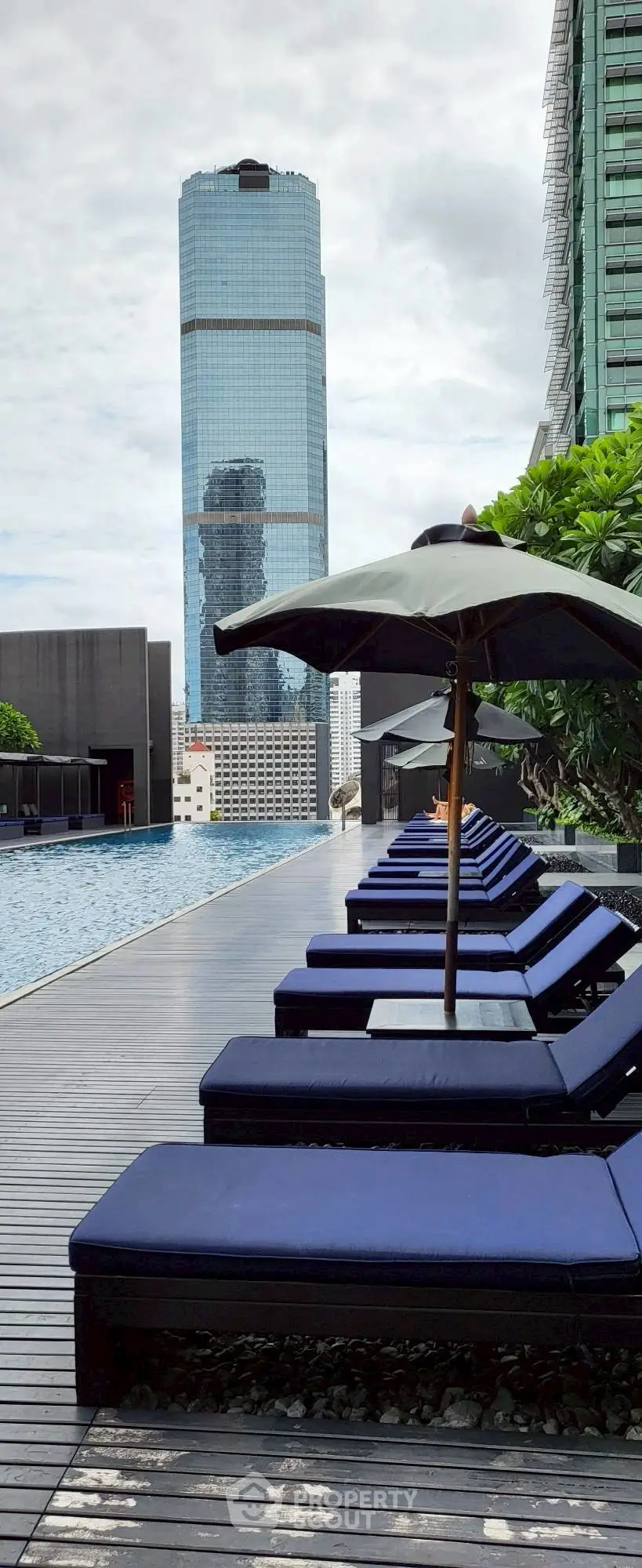 Luxurious rooftop pool area with modern skyscraper view and stylish lounge chairs.