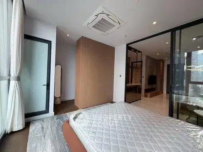 Spacious modern bedroom with large windows and stylish decor in a luxury apartment.