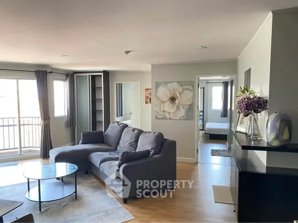 Spacious living room with modern decor and large windows in a stylish apartment.