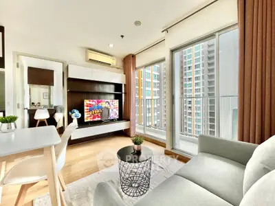 Modern living room with balcony and city view, featuring stylish furniture and natural light.