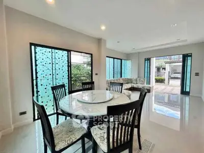 Spacious modern living room with elegant dining area and large windows for natural light.