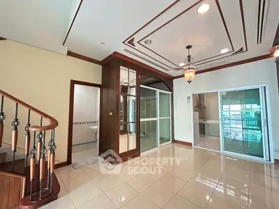 Spacious interior with elegant wooden staircase and modern lighting, perfect for stylish living.
