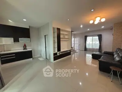 Spacious modern living room with open kitchen and elegant lighting
