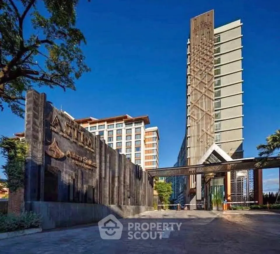 Stunning modern high-rise building with elegant entrance and lush surroundings.