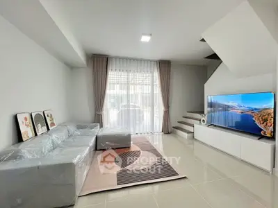 Modern living room with sleek furniture and large TV, perfect for relaxation.