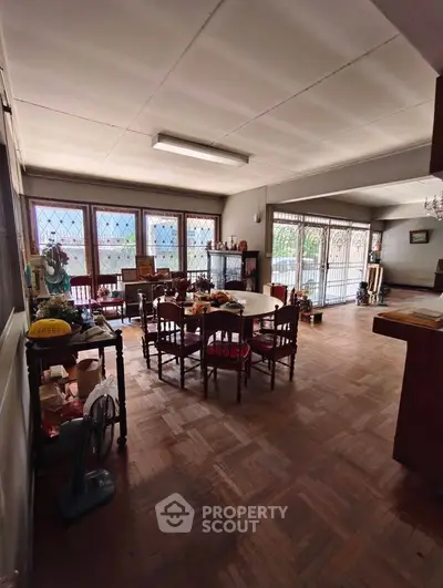 Spacious dining area with elegant wooden flooring and large windows for natural light.