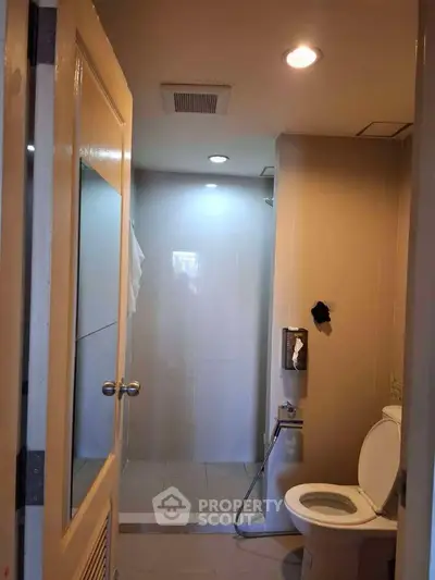 Modern bathroom with shower and toilet in a well-lit space.