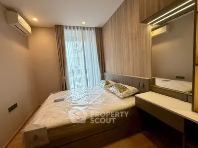 Modern bedroom with stylish decor and large window offering city views