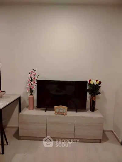 Modern living room with sleek TV stand and decorative flowers