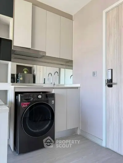 Modern kitchen with sleek cabinetry and integrated washer-dryer unit