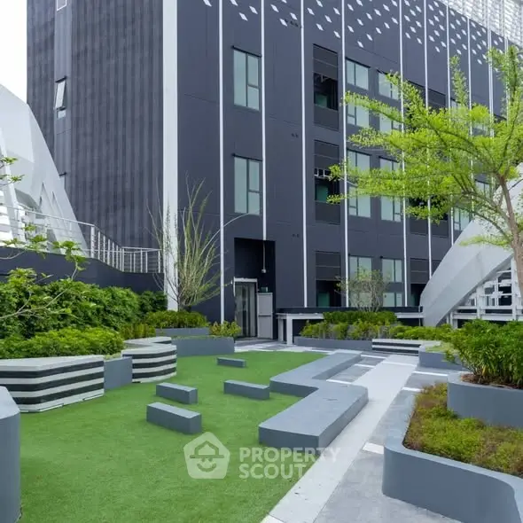 Modern building exterior with landscaped garden and seating area