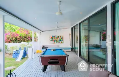 Stylish covered patio with pool table and garden view, perfect for entertainment and relaxation.