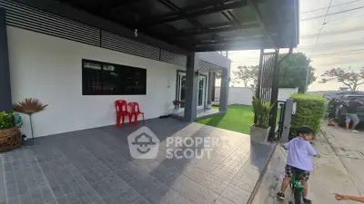 Modern home exterior with covered patio and lush green lawn