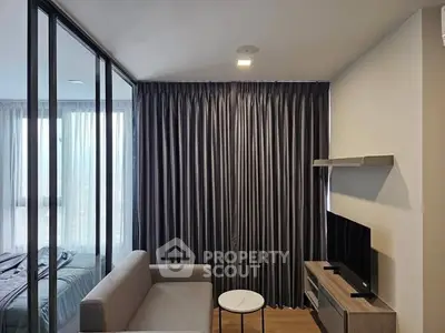 Modern living room with sleek design and glass partition to bedroom