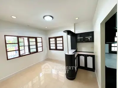 Spacious kitchen with modern cabinetry and ample natural light, perfect for culinary enthusiasts.