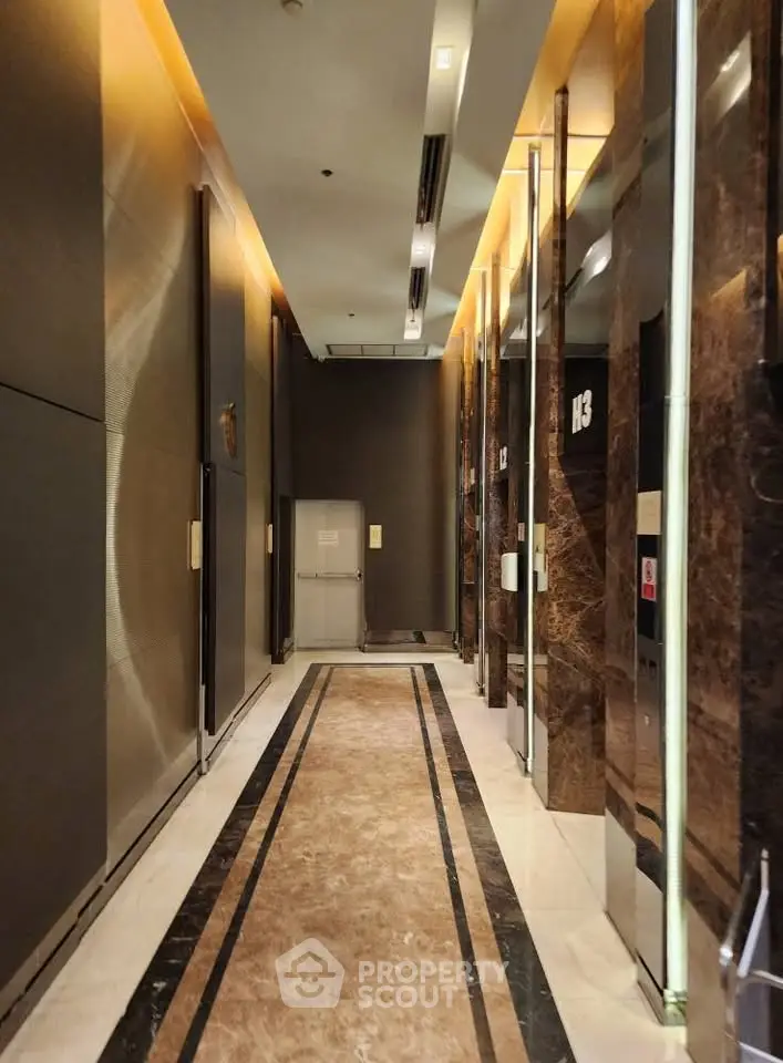 Luxurious modern elevator lobby with marble floors and elegant lighting.