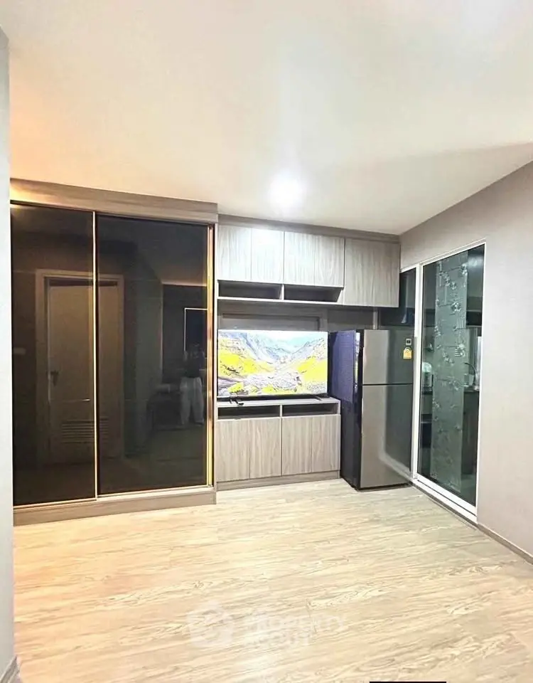 Modern kitchen with sleek cabinetry and stainless steel fridge in a bright apartment.