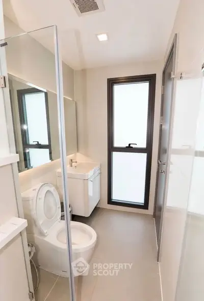 Modern bathroom with sleek fixtures and large window for natural light.
