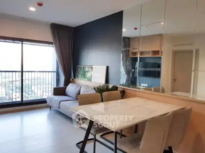 Modern living room with large windows and stylish dining area in a high-rise apartment.