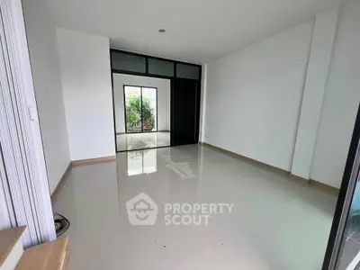Spacious empty room with large windows and glossy tiled floor, perfect for customization.
