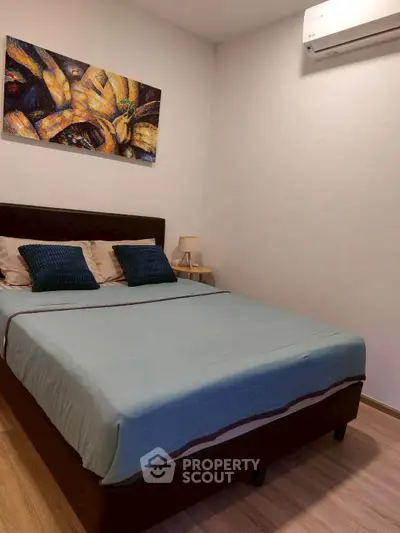 Cozy bedroom with modern decor and air conditioning, perfect for relaxation.