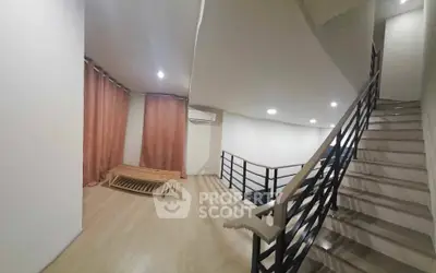 Spacious modern interior with staircase and wooden flooring, ideal for stylish living.