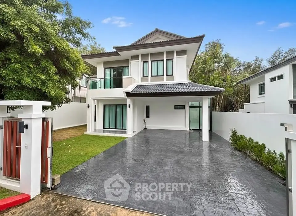 Stunning modern two-story house with spacious driveway and lush greenery, perfect for family living.