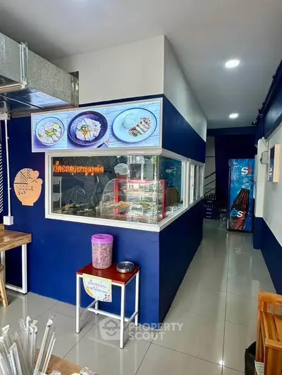 Charming small restaurant interior with modern blue and white decor, showcasing a cozy dining area and food display.