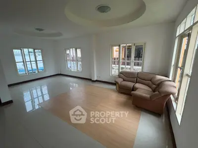Spacious living room with large windows and cozy sofa in a bright home.