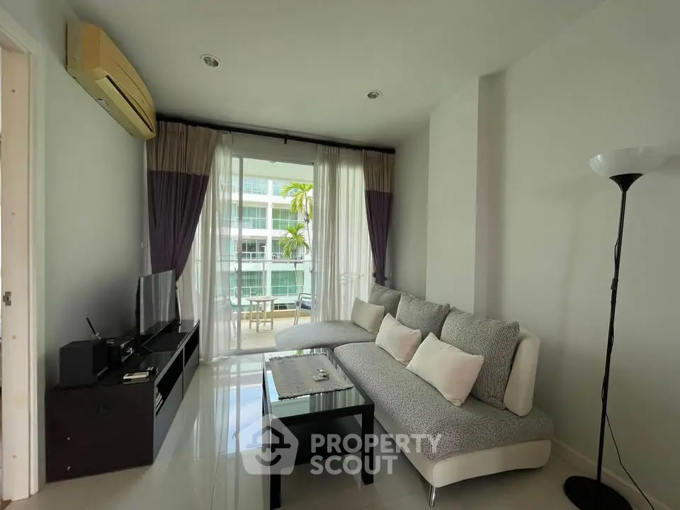 Modern living room with stylish sofa and balcony view in a contemporary apartment.