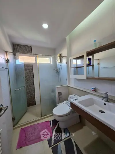 Modern bathroom with glass shower and sleek fixtures in a contemporary home.