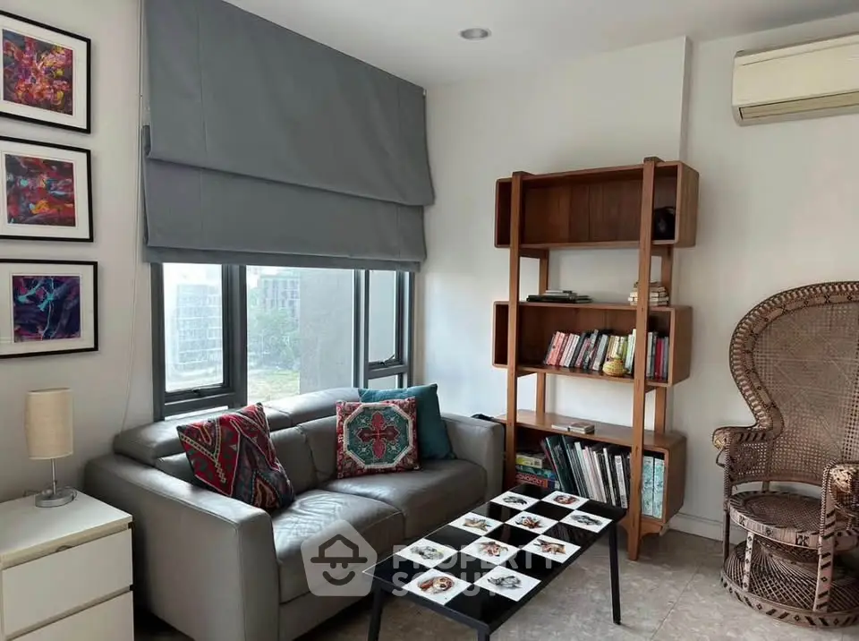 Chic living room with modern sofa, stylish bookshelf, and large window view.