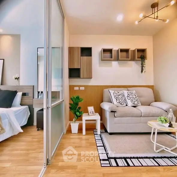 Modern studio apartment with stylish living area and cozy bedroom, featuring elegant decor and wooden flooring.