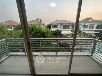 Charming balcony view overlooking suburban homes at sunset, perfect for relaxation.