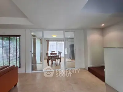 Spacious open-plan living area with dining room and large windows for natural light.